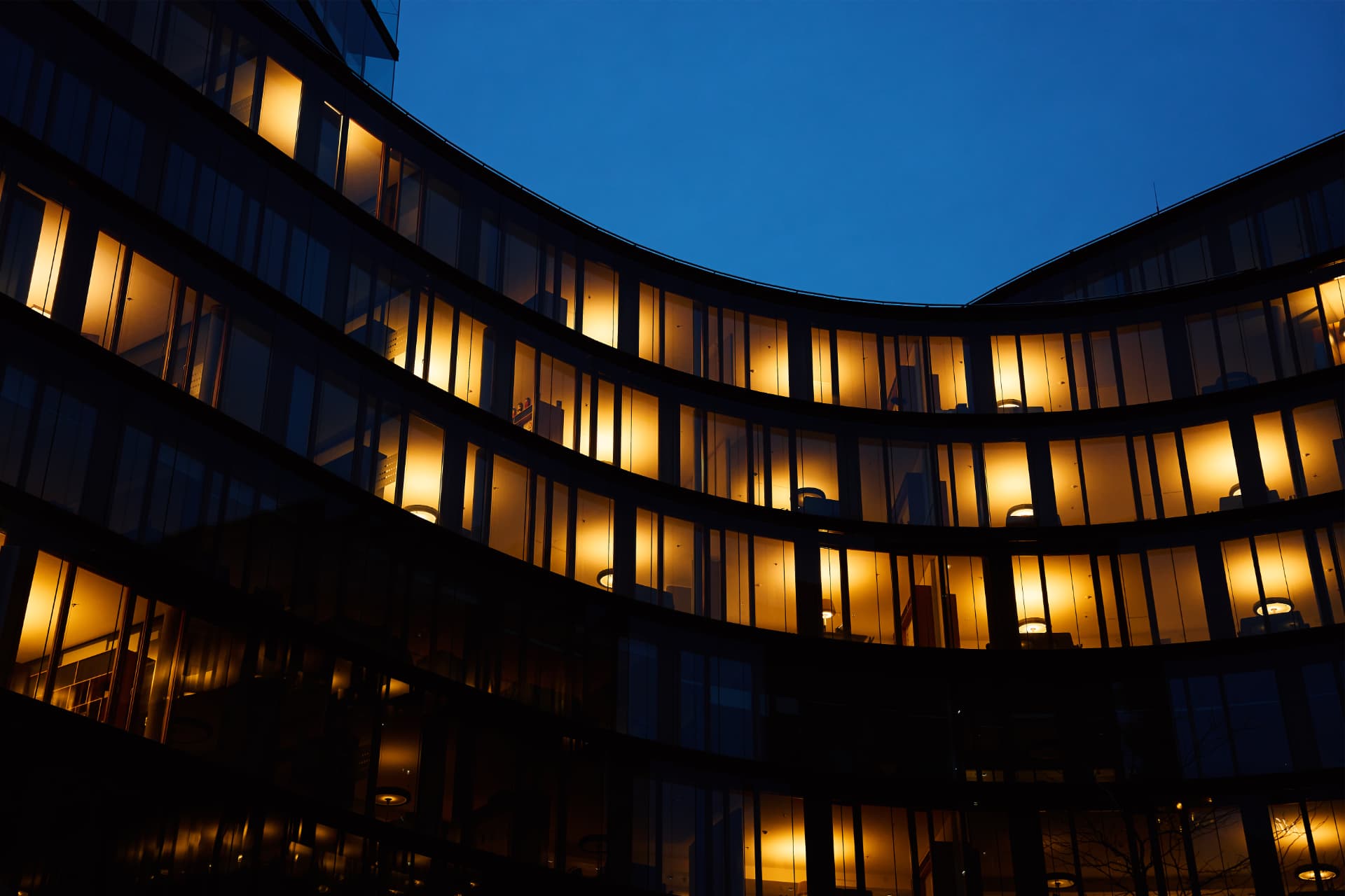 Modern building illuminated with warm lights at dusk